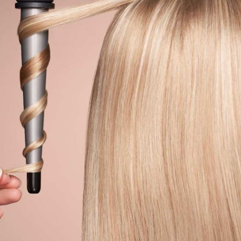 Woman with fine hair shocked as curls falling flat after using curling tools, showing hair texture and lasting curls struggle.